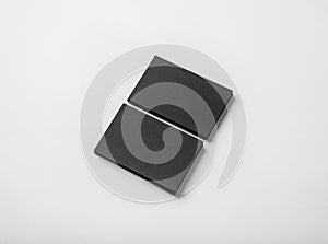 Two stack of blank black business cards on white background with soft shadows.