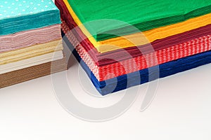 Two stacks of colorful paper napkins on white background