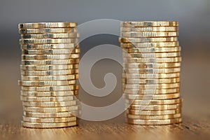 Two stacks of gold money coins coin in pile on blurred background