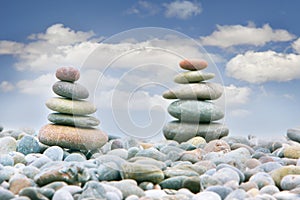 Two stacks of stones over sky background