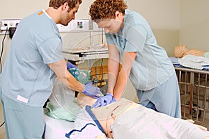 Two staff practicing CPR on mannequin