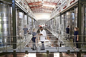 Two staff talking on gangway in a modern winemaking factory