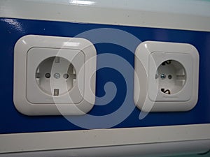 two standard North American duplex outlets mounted on a blue wall photo