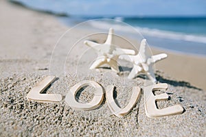 Two starfish with love message on Florida beach under the sun l