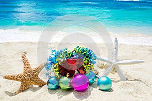Two Starfishes with Christmas balls and gift on the beach - holiday concept