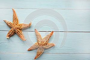 Two starfishes on wooden background. Copy space for the text.