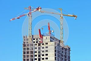 Two stationaty hoists over on a building of a skyscrape in front