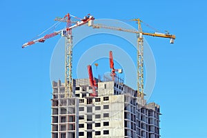 Two stationaty hoists over on a building of a skyscrape in front photo