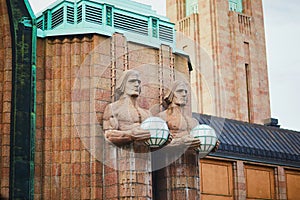Two statues holding streetlamps, main railway station in Helsinki, Finland