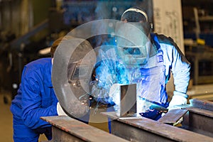 Two steel construction workers welding metal