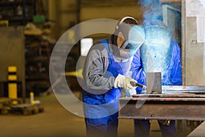 Two steel construction workers welding metal