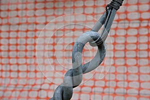 Two steel tie rods, hooked together with an orange safety net