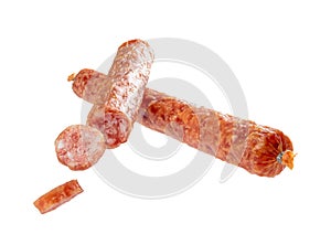 Two sticks of dry sausage in a natural shell, one whole, the other with cut slices, isolated on a white background. Full