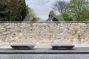 Two stone benches on the sidewalk of a city street photo