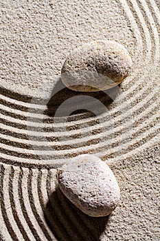 Two stones across sand lines for concept of spirituality