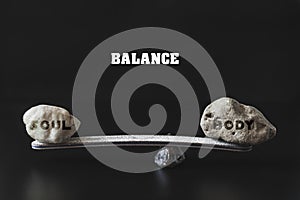 Two stones of different sizes lie on the lever, maintaining balance.