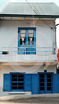 Two storey house in light color wall, blue paint wooden window and door at Da Lat