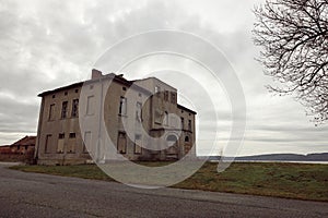 Two-storied building on the edge of the road, on the background of a gray sky