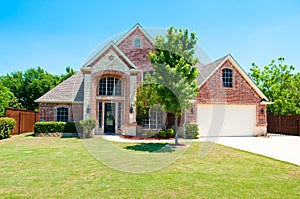 Two story brick home with the garage in the front.