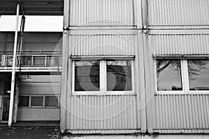 the two story building has windows and some stairs on each floor