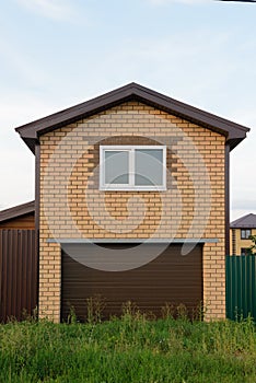 Two-story garage with roller shutters and a window