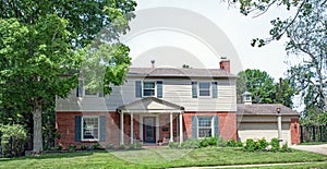 Two Story Red Brick & Vinyl House with Blue Shutters