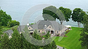 Two-story residential waterfront house on lake Ontario shore in rural living area in Rochester, NY. American dream home