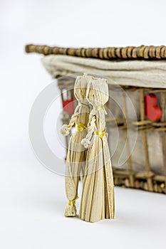Two straw dolls in front of an old casket