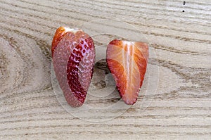 Two strawberries, one strawberry cut in half