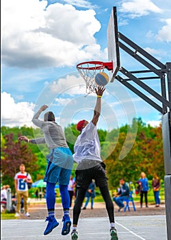 Two street basketball players having training outdoor. They are making a good action.