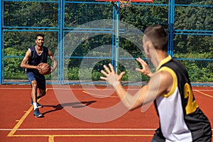 Two street basketball players playing on court.