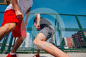 Two street basketball players playing one on one lot of close up action and guarding the ball