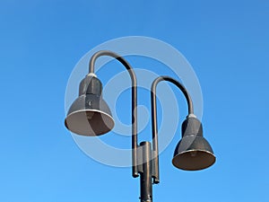 Two street lamps in the daytime