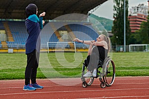 Two strong and inspiring women, one Muslim in a burka and the other in a wheelchair stretching necks while on the