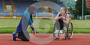 Two strong and inspiring women, one a Muslim wearing a burka and the other in a wheelchair stretching and preparing