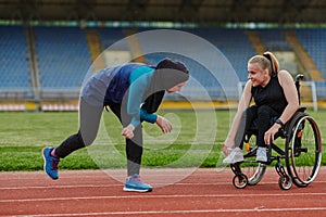 Two strong and inspiring women, one a Muslim wearing a burka and the other in a wheelchair stretching and preparing