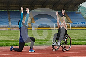 Two strong and inspiring women, one a Muslim wearing a burka and the other in a wheelchair stretching and preparing