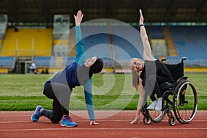 Two strong and inspiring women, one a Muslim wearing a burka and the other in a wheelchair stretching and preparing