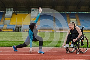 Two strong and inspiring women, one a Muslim wearing a burka and the other in a wheelchair stretching and preparing