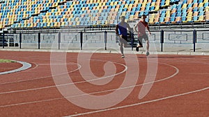 Two strong rivals competing at stadium, running fast, preparing for marathon