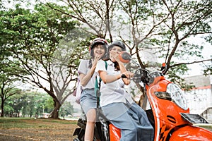 Two student girls wearing helmets laughing happily