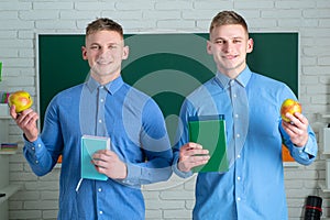 Two student holding books and smiling at camera. Learning and education concept. Group of high school students in