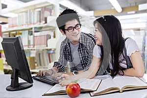 Two student laughing in library