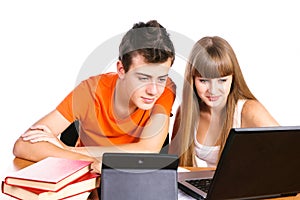 Two students learning with books and laptop