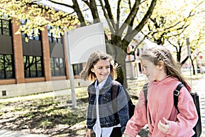 Two students outside at school standing together