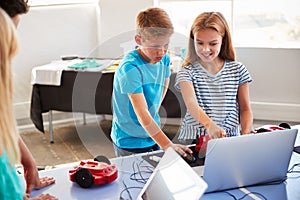 Two Students In After School Computer Coding Class Learning To Program Robot Vehicle