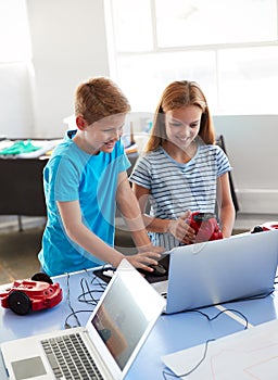 Two Students In After School Computer Coding Class Learning To Program Robot Vehicle