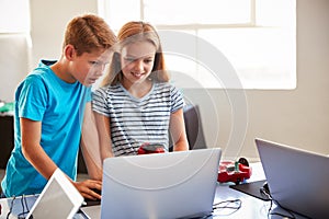 Two Students In After School Computer Coding Class Learning To Program Robot Vehicle