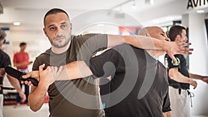 Two students train knife disarm techniques on martial arts seminar photo