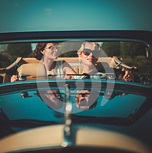 Two stylish ladies in a classic convertible